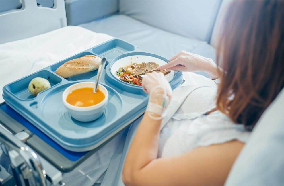 woman in a hospital bed eating