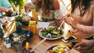 Friends at a restaurant enjoying vegetarian food