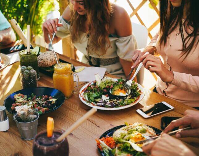 Friends at a restaurant enjoying vegetarian food