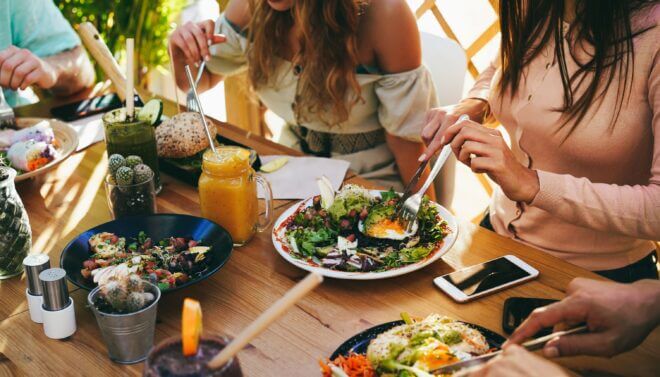 Friends at a restaurant enjoying vegetarian food